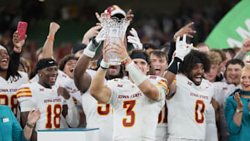 Iowa State quarterback Rocco Becht holds up the trophy after defeating Kansas State.