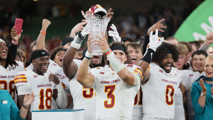 Iowa State quarterback Rocco Becht holds up the trophy after defeating Kansas State.