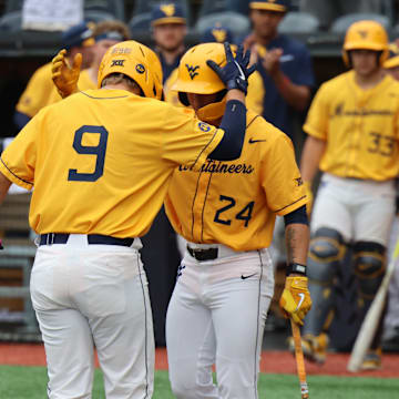 West Virginia University first baseman Grant Hussey is greeted by third baseman Chase Swain after a solo home run against Texas Tech.