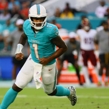 Miami Dolphins quarterback Tua Tagovailoa (1) runs on the field after passing the football against the Washington Commanders during the first quarter of a preseason game at Hard Rock Stadium. 