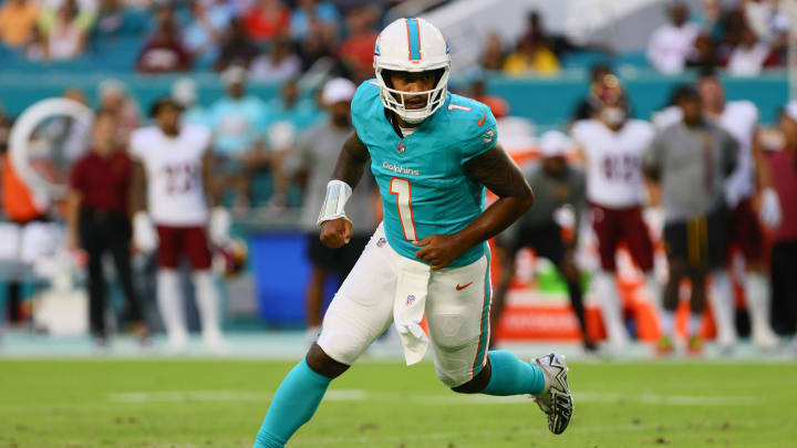 Miami Dolphins quarterback Tua Tagovailoa (1) runs on the field after passing the football against the Washington Commanders during the first quarter of a preseason game at Hard Rock Stadium. 