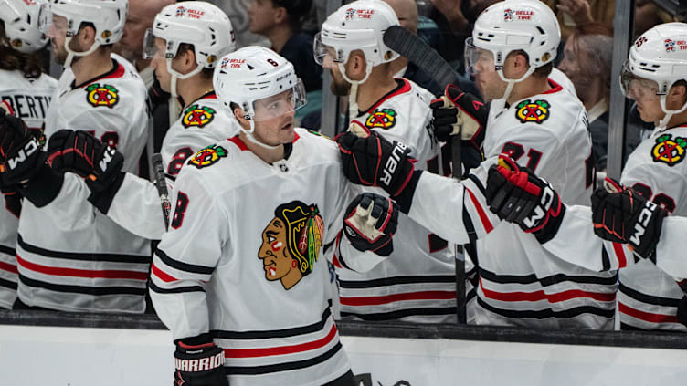 Nov 14, 2024; Seattle, Washington, USA;  Chicago Blackhawks forward Ryan Donato (8) is congratulated by teammates on the bench after scoring a goal during the third period against the Seattle Kraken at Climate Pledge Arena. Mandatory Credit: Stephen Brashear-Imagn Images