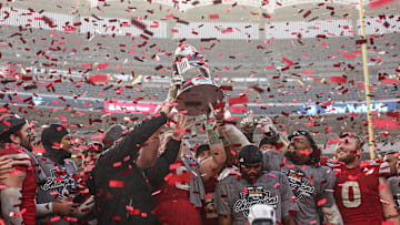 Dec 28, 2024; Bronx, NY, USA; Nebraska Cornhuskers head coach Matt Rhule holds the championship trophy as Cornhuskers players celebrate after the game against the Boston College Eagles at Yankee Stadium. Mandatory Credit: Vincent Carchietta-Imagn Images