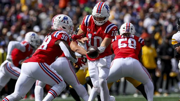 New England Patriots quarterback Drake Maye (10) hands off the ball to New England Patriots running back Rhamondre Stevenson.