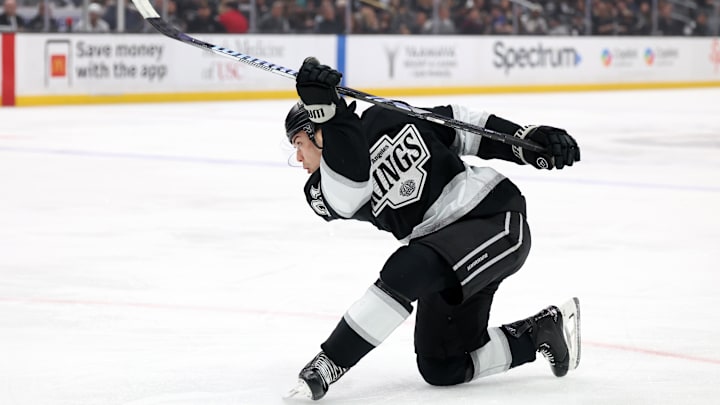 Apr 7, 2025; Los Angeles, California, USA;  Los Angeles Kings defenseman Jordan Spence (21) shoots the puck during the second period against the Seattle Kraken at Crypto.com Arena. Mandatory Credit: Kiyoshi Mio-Imagn Images