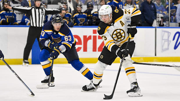 Hockey player in white uniform skates with the puc