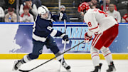 Penn State Nittany Lions forward Aiden Fink (18) shoots as Boston University Terriers forward Shane Lachance (18) defends during the third period of the Frozen Four college ice hockey national semifinals at Enterprise Center.