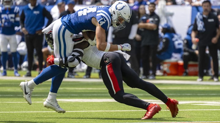 Sep 8, 2024; Indianapolis, Indiana, USA; Indianapolis Colts wide receiver Alec Pierce (14) is hit by Houston Texans linebacker Azeez Al-Shaair (0) causing a fumble during the second quarter at Lucas Oil Stadium. Mandatory Credit: Marc Lebryk-Imagn Images