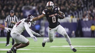 Dec 27, 2023; Houston, TX, USA; Oklahoma State Cowboys running back Ollie Gordon II (0) runs with the ball as Texas A&M Aggies linebacker Chris Russell Jr. (24) attempts to make a tackle during the first quarter at NRG Stadium. Mandatory Credit: Troy Taormina-USA TODAY Sports