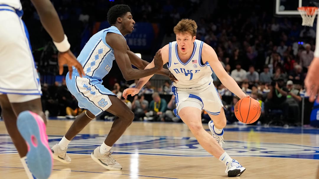 Mar 14, 2025; Charlotte, NC, USA; Duke Blue Devils guard Kon Knueppel (7) with the ball as North Carolina Tar Heels guard Drake Powell (9) defends in the first half at Spectrum Center. Mandatory Credit: Bob Donnan-Imagn Images