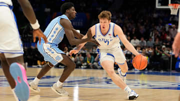 Mar 14, 2025; Charlotte, NC, USA; Duke Blue Devils guard Kon Knueppel (7) with the ball as North Carolina Tar Heels guard Drake Powell (9) defends in the first half at Spectrum Center. Mandatory Credit: Bob Donnan-Imagn Images