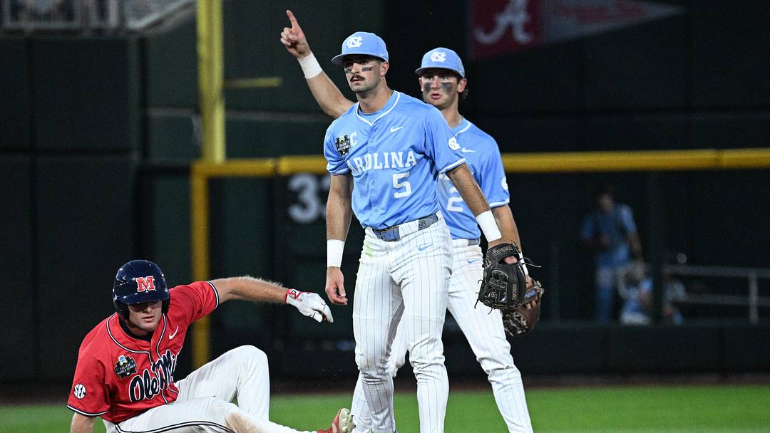 Jun 12, 2026; Omaha, NE, USA; North Carolina Tar Heels shortstop Jake Schaffner (2) and shortstop Jake Schaffner (2) complete a double play as Mississippi Rebels pinch runner Cannon Goldin (4) watches in the ninth inning at Charles Schwab Field. Mandatory Credit: Steven Branscombe-Imagn Images