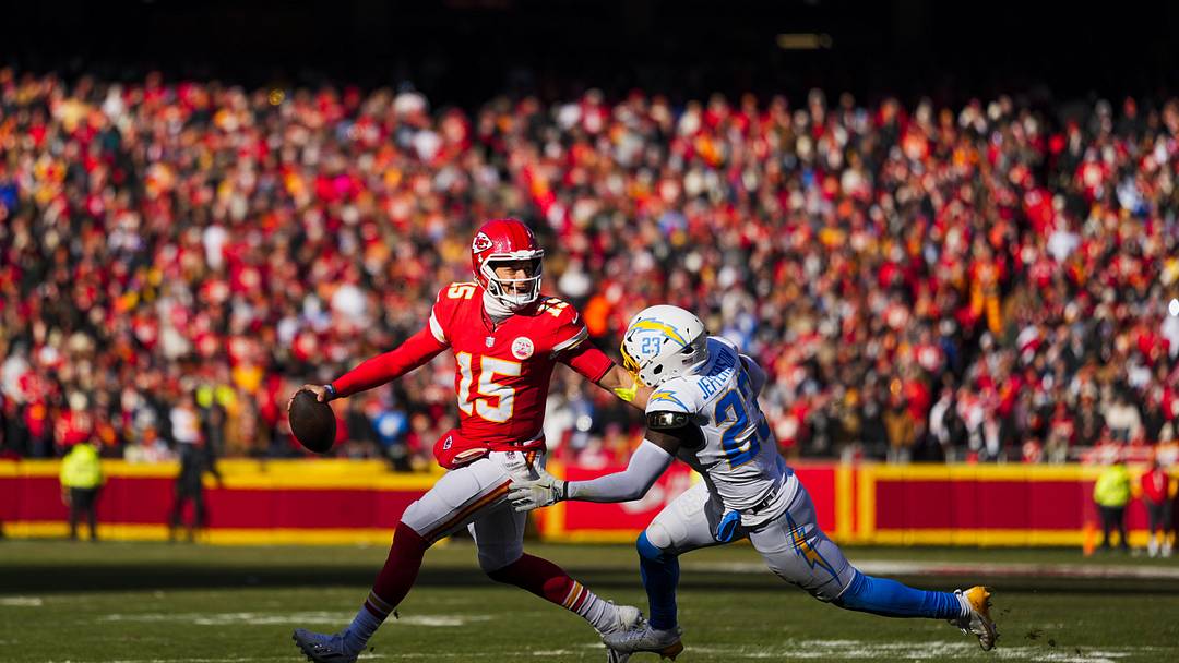 Dec 14, 2025; Kansas City, Missouri, USA; Kansas City Chiefs quarterback Patrick Mahomes (15) looks to pass under pressure from Los Angeles Chargers safety Tony Jefferson (23) during the second quarter at GEHA Field at Arrowhead Stadium. Mandatory Credit: Jay Biggerstaff-Imagn Images