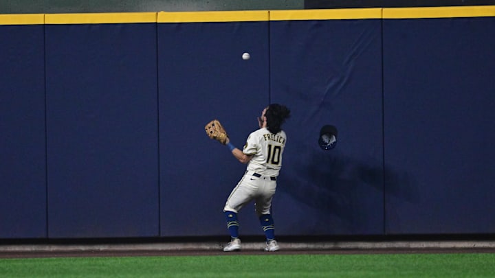 Brewers center fielder Sal Frelick fields a ball after stopping it from going over the frence. Brewers center fielder Sal Frelick fields a ball after stopping it from going over the frence.