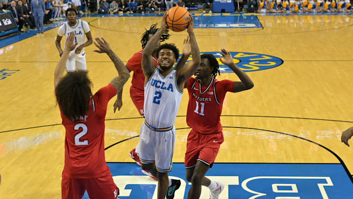 Feb 3, 2026; Los Angeles, California, USA;  UCLA Bruins guard Donovan Dent (2) is defended by Rutgers Scarlet Knights guard Lino Mark (2) and Rutgers Scarlet Knights forward Chris Nwuli (11) as he drives for a basket in the first half at Pauley Pavilion presented by Wescom Financial. Mandatory Credit: Jayne Kamin-Oncea-Imagn Images