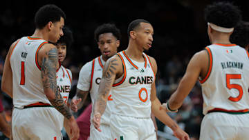 Jan 8, 2025; Coral Gables, Florida, USA; Miami Hurricanes guard Matthew Cleveland (0) high-fives with teammates against the Florida State Seminoles during the second half at Watsco Center. Mandatory Credit: Sam Navarro-Imagn Images