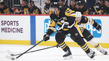 Apr 13, 2025; Pittsburgh, Pennsylvania, USA; Pittsburgh Penguins defenseman Conor Timmins (20) skates with the puck against Boston Bruins left wing Cole Koepke (45) during the second period at PPG Paints Arena. Mandatory Credit: Charles LeClaire-Imagn Images