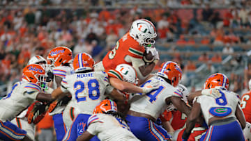 Sep 20, 2025; Miami Gardens, Florida, USA; Miami Hurricanes running back CharMar Brown (6) jumps over the pile for a touchdown against the Florida Gators during the fourth quarter at Hard Rock Stadium. Mandatory Credit: Sam Navarro-Imagn Images