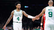 Oct 15, 2025; Boston, Massachusetts, USA; Boston Celtics guard Anfernee Simons (4) high fives Boston Celtics guard Derrick White (9) during the first half against the Toronto Raptors at TD Garden. Mandatory Credit: Paul Rutherford-Imagn Images