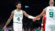 Oct 15, 2025; Boston, Massachusetts, USA; Boston Celtics guard Anfernee Simons (4) high fives Boston Celtics guard Derrick White (9) during the first half against the Toronto Raptors at TD Garden. Mandatory Credit: Paul Rutherford-Imagn Images