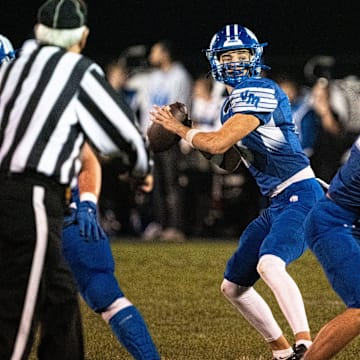 Van Meter's Henry Lounsbury looks to attempt a pass during a first round playoff football game at Van Meter High School on Friday, Oct. 24, 2025, in Van Meter.