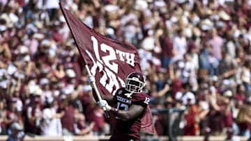 Sep 27, 2025; College Station, Texas, USA; Texas A&M Aggies defensive end Nana Boadi-Owusu (12) runs out with the 12th man flag prior to the game against the Auburn Tigers at Kyle Field. Mandatory Credit: Maria Lysaker-Imagn Images 