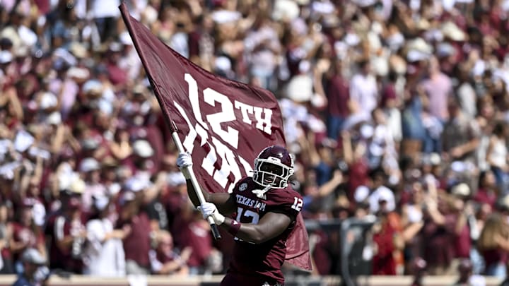 Sep 27, 2025; College Station, Texas, USA; Texas A&M Aggies defensive end Nana Boadi-Owusu (12) runs out with the 12th man flag prior to the game against the Auburn Tigers at Kyle Field. Mandatory Credit: Maria Lysaker-Imagn Images 