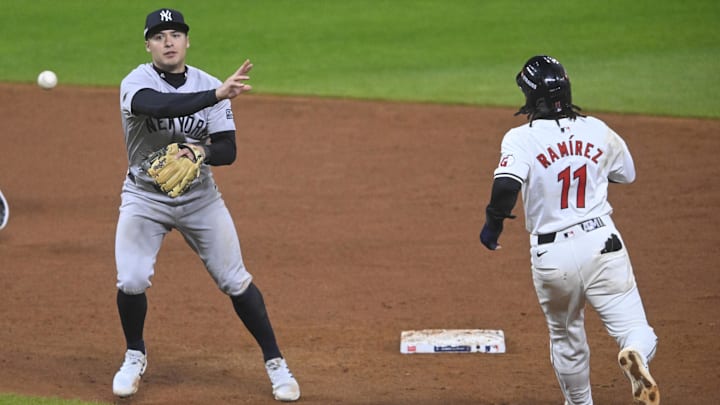 Oct 17, 2024; Cleveland, Ohio, USA; New York Yankees shortstop Anthony Volpe (11) turns a double play against Cleveland Guardians third baseman Jose Ramirez (11) during the ninth inning in game 3 of the American League Championship Series at Progressive Field. Mandatory Credit: David Richard-Imagn Images