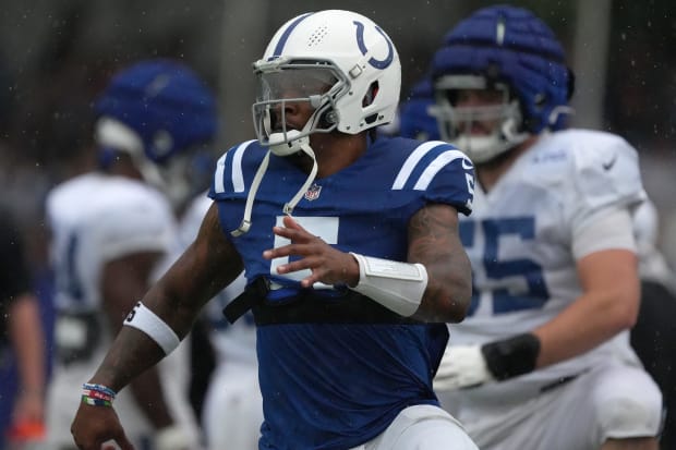 Football player Anthony Richardson warms up before practice in a bluejersey.