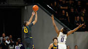 Nov 9, 2025; Waco, Texas, USA;  Baylor Bears guard Cameron Carr (43) scores a three-point basket against Washington Huskies guard Quimari Peterson (0) during the first half at Paul and Alejandra Foster Pavilion. Mandatory Credit: Chris Jones-Imagn Images
