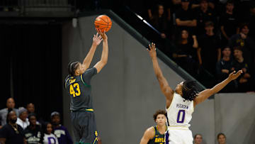 Nov 9, 2025; Waco, Texas, USA;  Baylor Bears guard Cameron Carr (43) scores a three-point basket against Washington Huskies guard Quimari Peterson (0) during the first half at Paul and Alejandra Foster Pavilion. Mandatory Credit: Chris Jones-Imagn Images