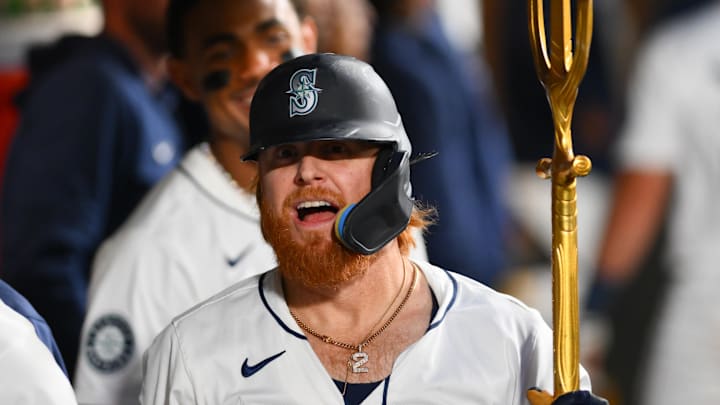 Seattle Mariners designated hitter Justin Turner celebrates in the dugout after hitting a home run