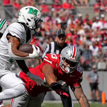 Marshall Thundering Herd running back A.J. Turner (5) is pursued by Ohio State Buckeyes defensive tackle Hero Kanu (93) during the first half of an NCAA Division I football game at Ohio Stadium on Saturday.