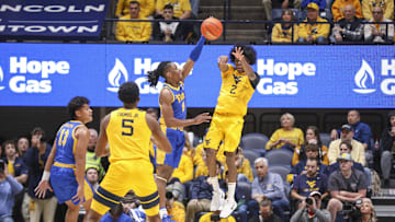 Nov 13, 2025; Morgantown, West Virginia, USA; West Virginia Mountaineers guard Amir Jenkins (2) makes a pass against Pittsburgh Panthers guard Omari Witherspoon (8) during the first half at WVU Coliseum. Mandatory Credit: Ben Queen-Imagn Images