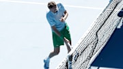Daniil Medvedev smashes his racket on a camera on the net.