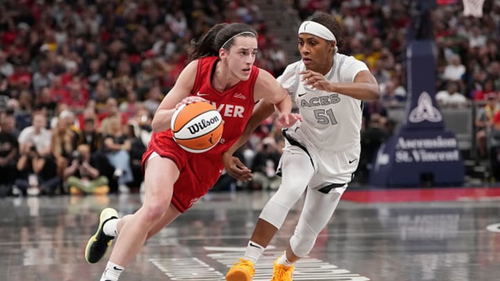 Caitlin Clark #22 of the Indiana Fever dribbles the ball while being guarded by Sydney Colson #51 of the Las Vegas Aces in the first quarter at Gainbridge Fieldhouse on September 11, 2024 in Indianapolis, Indiana. 