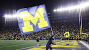 The Michigan Wolverines flag is waved after a touchdown is scored at Michigan Stadium.