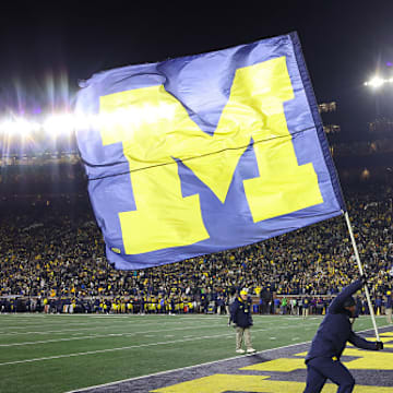 The Michigan Wolverines flag is waved after a touchdown is scored at Michigan Stadium.
