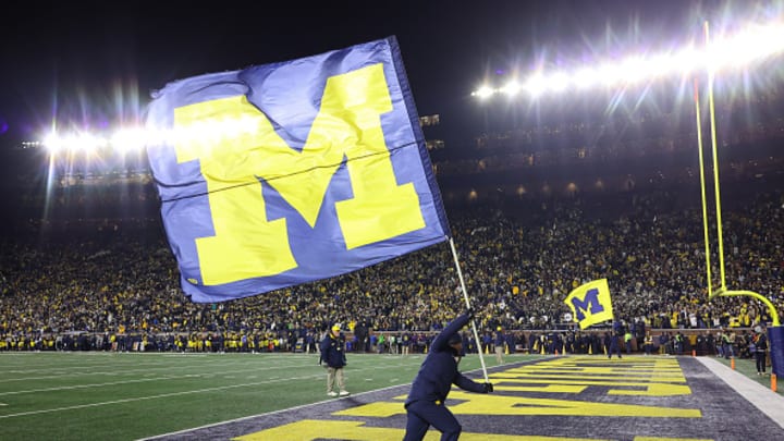 The Michigan Wolverines flag is waved after a touchdown is scored at Michigan Stadium.