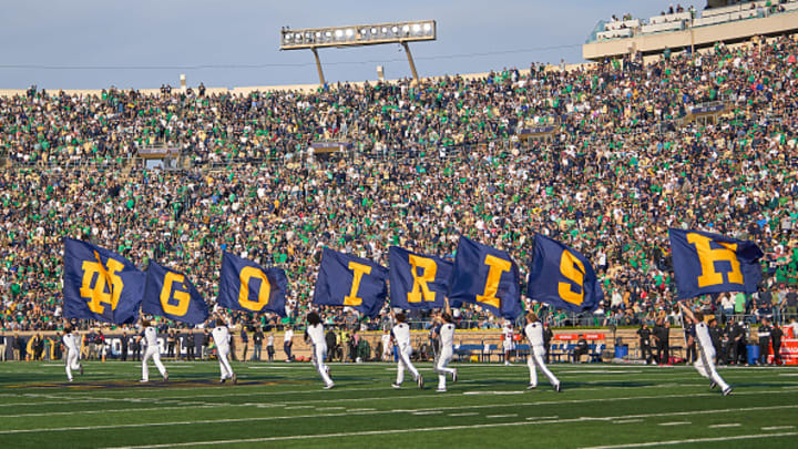 "Go Irish" flag runners go across the field during a Notre Dame game.