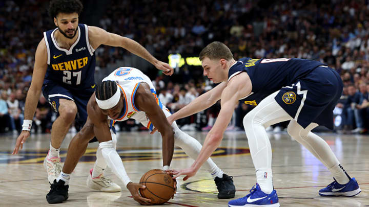 Shai Gilgeous-Alexander (2) de Oklahoma City Thunder batalla para evitar perder el balón ante Jamal Murray (27) y Christian Braun (0), de los Denver Nuggets durante la serie de playoffs de estos equipos en la NBA. El duelo a ganar cuatro de siete partidos está empatado 2-2.