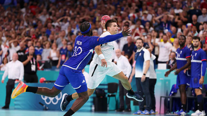 Renars Uscins of Germany scores a goal whilst under pressure from Dika Mem of France to force overtime during the Men's Quarterfinal match between Germany and France on day 12 of the Olympic Games Paris 2024 at Stade Pierre Mauroy on August 07, 2024 in Lille, France.