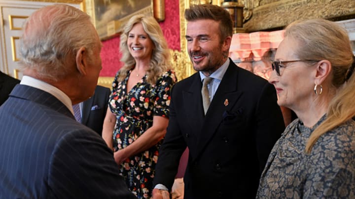 El ahora Sir David Beckham estrecha la mano de Charles lll, rey de Gran Bretaña. 
