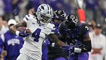 Dec 3, 2022; Arlington, TX, USA; Kansas State Wildcats wide receiver Malik Knowles (4) stiff arms TCU Horned Frogs safety Mark Perry (3) as he runs for a first down during the second quarter at AT&T Stadium. Mandatory Credit: Jerome Miron-Imagn Images