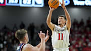 Nov 11, 2025; Cincinnati, Ohio, USA; Cincinnati Bearcats guard Kerr Kriisa (11) shoots against Dayton Flyers guard Jordan Derkack (4) in the second half at Fifth Third Arena. Mandatory Credit: Aaron Doster-Imagn Images