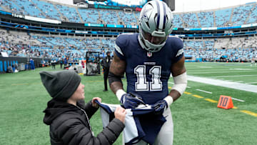 Dec 15, 2024; Charlotte, North Carolina, USA;  Dallas Cowboys linebacker Micah Parsons (11) signs a jersey for a fan before the game at Bank of America Stadium. Mandatory Credit: Bob Donnan-Imagn Images