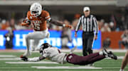 Nov 28, 2025; Austin, Texas, USA; Texas Longhorns running back Quintrevion Wisner (5) leaps over Texas A&M Aggies cornerback Will Lee III (4) during the first half against the Texas Longhorns at Darrell K Royal-Texas Memorial Stadium. Mandatory Credit: Scott Wachter-Imagn Images