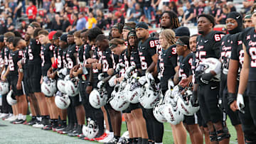 Nov 1, 2025; Houston, Texas, USA; Before the game the Houston Cougars stand for a moment of silence for Houston coach Kurt Hester at TDECU Stadium. Hester passed away on October 25, 2025, from stage IV melanoma after an eight-month battle with the disease. Mandatory Credit: Thomas Shea-Imagn Images