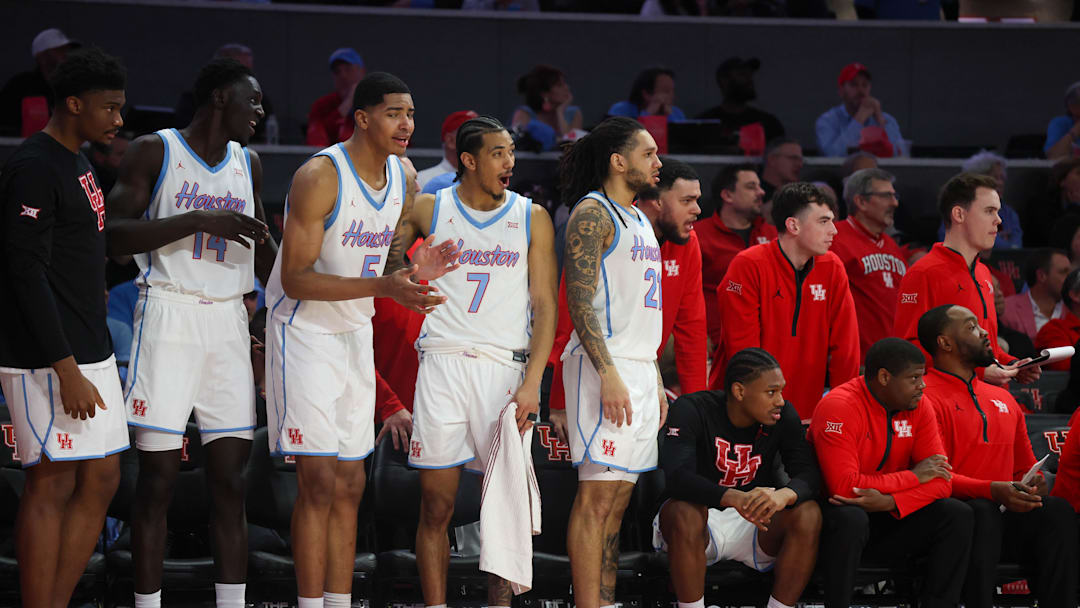Jan 13, 2026; Houston, Texas, USA; Houston Cougars forward Kalifa Sakho (14) center Chris Cenac Jr. (5)  guard Milos Uzan (7) and  guard Emanuel Sharp (21) react while they watch their teammates play against the West Virginia Mountaineers in the second half  at Fertitta Center. Mandatory Credit: Thomas Shea-Imagn Images