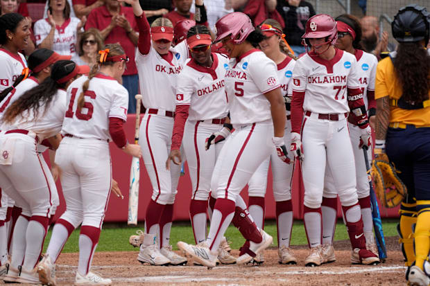 Oklahoma infielder Ella Parker (5) is greeted at home by teammates after hitting home run in the fourth inning.